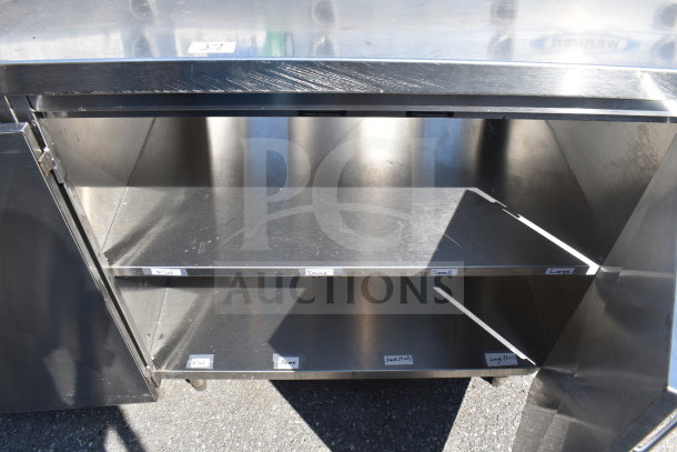 Commercial counter with 4 doors, stainless steel, interior shelving with labeled sections, good condition.