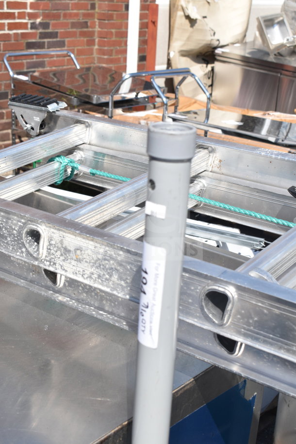 Two metal umbrella bases with visible signs of wear. A label indicates auction details.