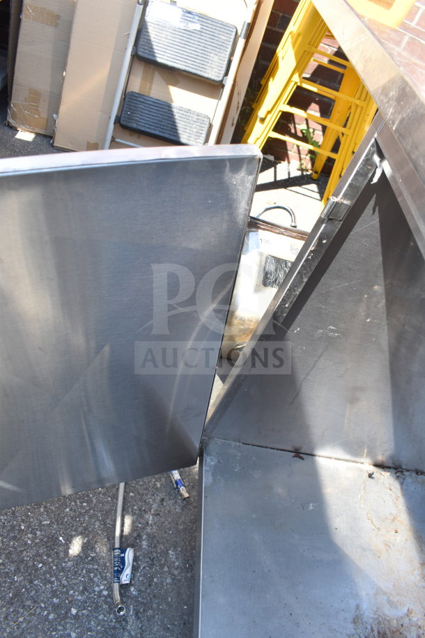 Commercial counter with 2-bay sink, 4 doors. Stainless steel finish, visible wear. Ideal for kitchen use.