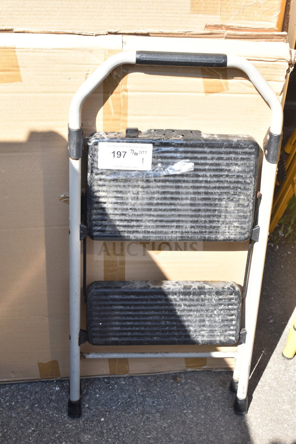 Sturdy A-frame ladder with textured black steps, used condition. Label reads "197, 7/10 QTY." Ideal for household use.