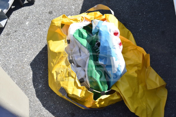 Yellow bag containing various colorful items including a costume. Some wear visible. Part of auction lot with Slim Jim trash can included.