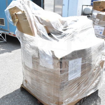 Pallet of 21 brand new scratch and dent items, including towels, fry cutter, and table, wrapped in plastic. Labels visible.