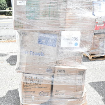 Pallet of assorted items including straws, gloves, cups, and paper towels, wrapped in plastic, branded cartons visible.
