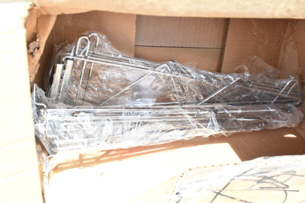 Cardboard box with wrapped metal frames. Part of 12 new scratch and dent items including a mop sink and utility cart.