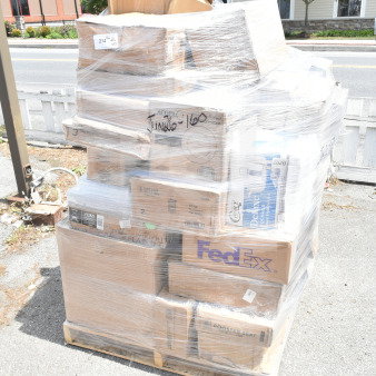 Shrink-wrapped pallet of 33 scratch and dent items, including boxes labeled with glasses, containers, and saucers.