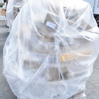 Pallet with 35 brand new scratch-and-dent items, including plates and hotel pans, wrapped in protective plastic.