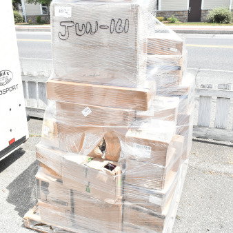Pallet with 42 new scratch and dent items, including glasses and compressor, wrapped in plastic. Visible box label: "Glad 20 Gallon Step Can."