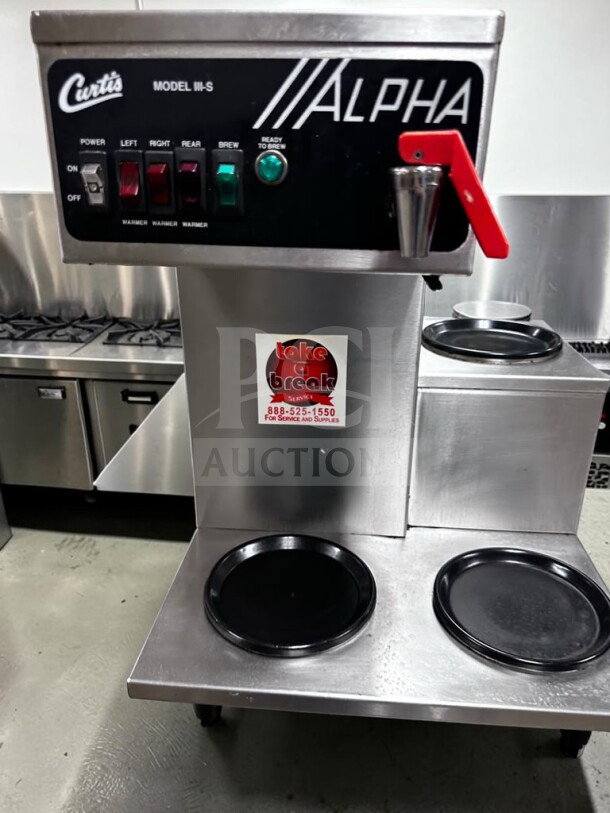 Wilbur Curtis ALPHA-IIIS Commercial 3-Station Coffee Brewer in stainless steel, fully operational, features visible controls.