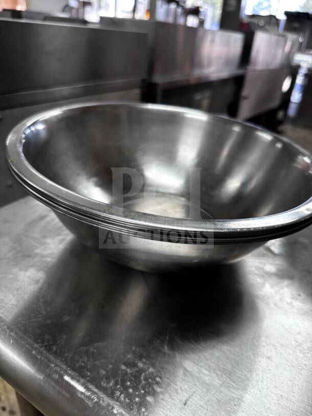 Stainless steel commercial mixing bowl, well-maintained, approx. 13" diameter, by Commercial Kitchen Smallwares, ready for use.
