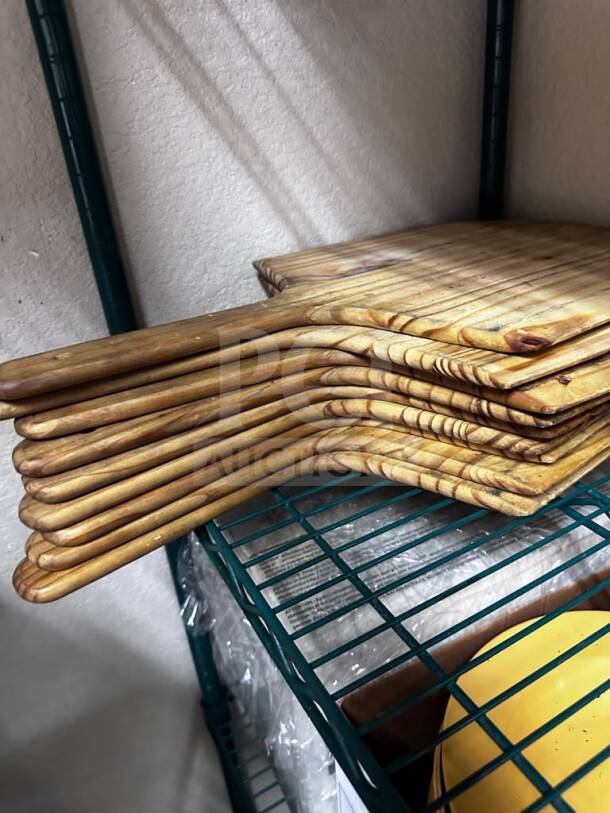 Wooden commercial pizza peels, quantity 9, by Commercial Kitchen Smallwares, well-maintained, ready for restaurant use.