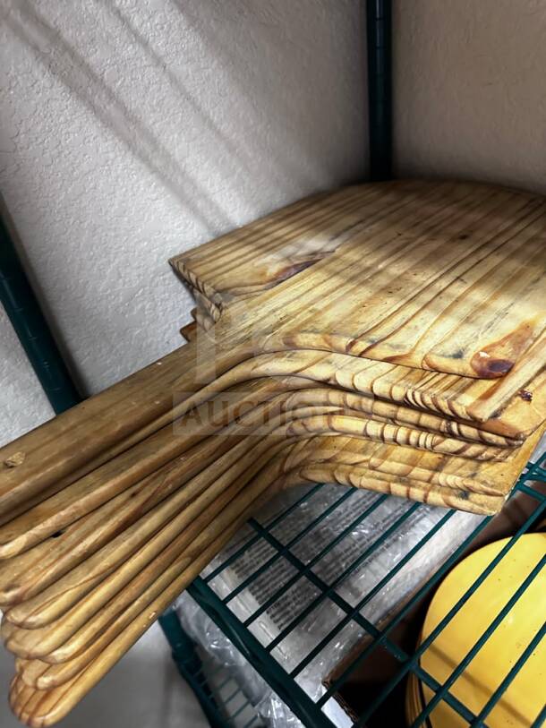 Nine wooden pizza peels by Commercial Kitchen Smallwares, well-maintained, ready for use in restaurant settings.