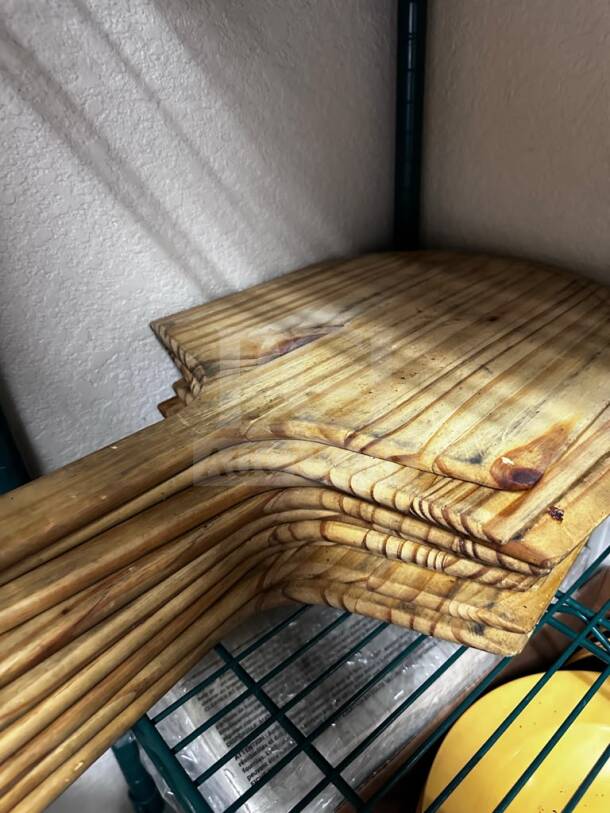 Nine wooden commercial pizza peels in well-maintained condition, by Commercial Kitchen Smallwares, ready for use.