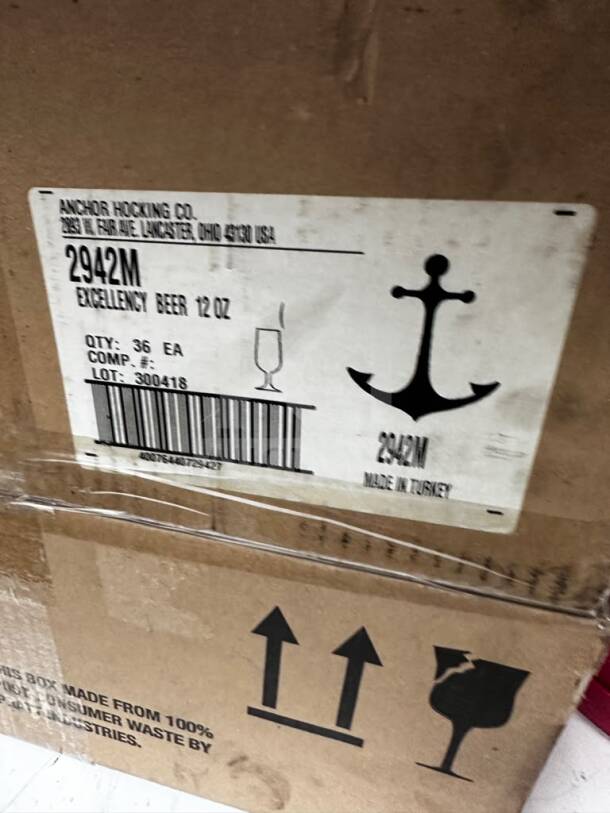 Two cases of Anchor Hocking 2942M Excellency 12 oz glass pilsners. Brand new, 72 total. Box labels show model, brand, and details.
