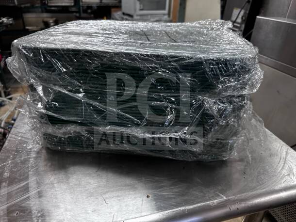 Stack of wrapped Cambro 1216414 teal cafeteria trays, 12"x16", superior condition, NSF certified, ready for commercial use.