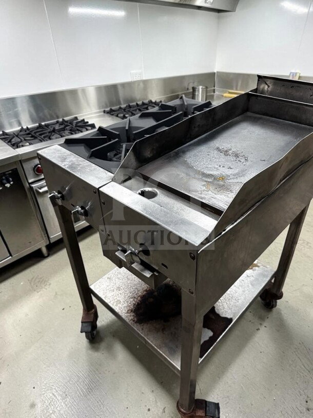 Commercial 24” portable propane cooktop with two 12” open flame burners and 12” iron griddle on stainless steel stand.