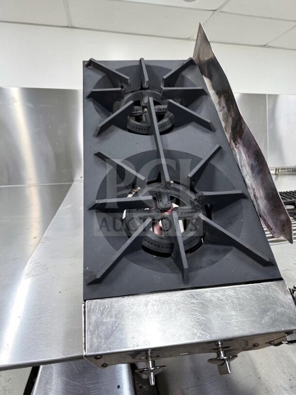 Commercial 24” propane cooktop with two 12” burners and a 12” iron griddle on a stainless steel stand. Fully tested.