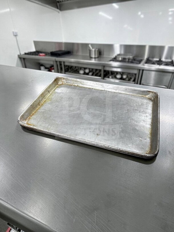 Commercial Kitchen Smallwares 1/2 Size Aluminum Sheet Pan, durable, used condition, ideal for professional baking.
