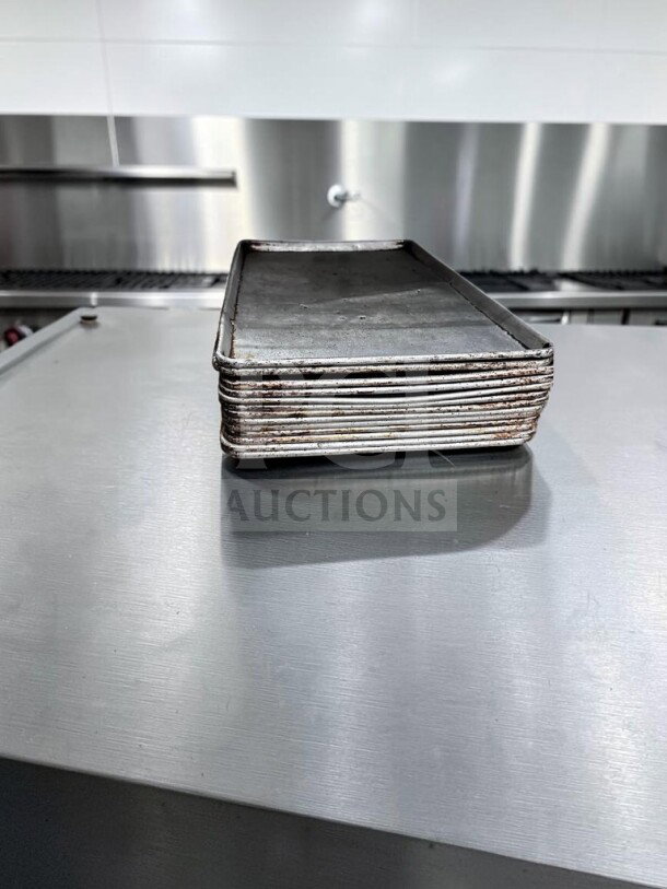 Stack of 13 full-size aluminum sheet pans by Commercial Kitchen Smallwares, model ALU-S-PAN-1178, in well-maintained condition.