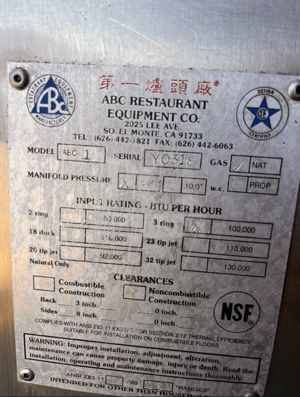 Metal label on ABC Restaurant Equipment ABC-1 Wok Range, 100,000–110,000 BTU, NSF certified, showing model and serial details.