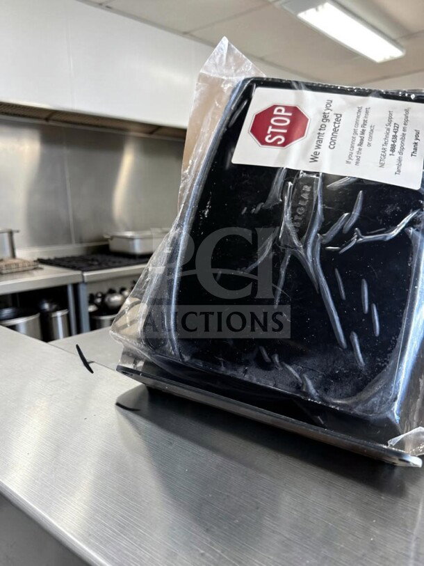 Brand new Netgear DGND3700-100NAS N600 modem router in packaging with "Stop" connection label visible.