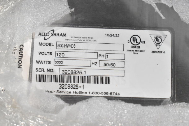 Alto Shaam 500-HW/D6 label showing model, voltage (120V), phase (1), UL listing, and serial number amid packaging.