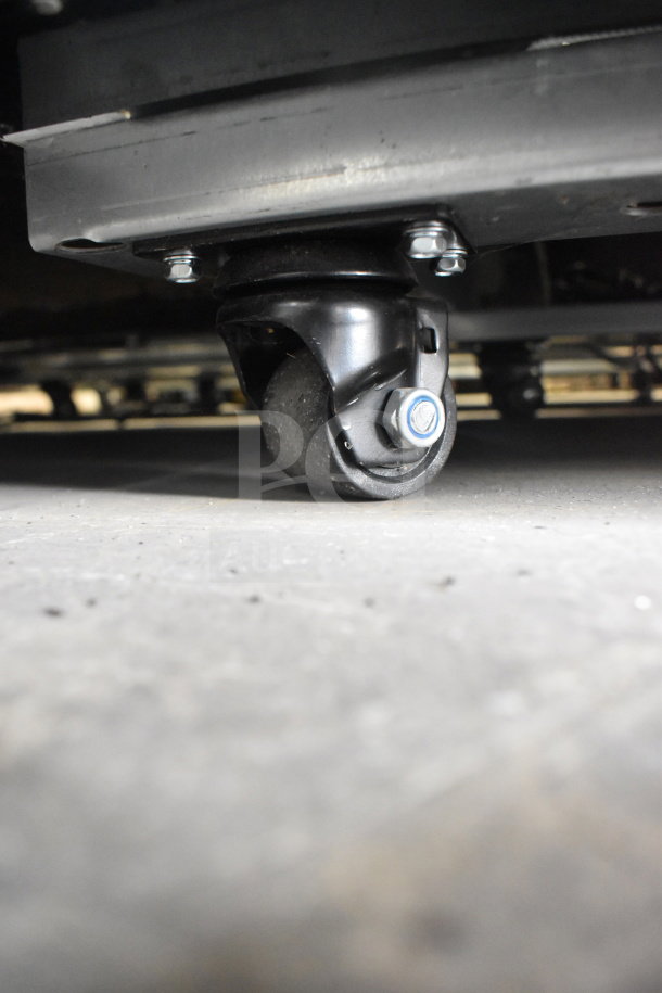 Close-up of a caster wheel on a 2022 Migali C-49FM-HCe commercial freezer, highlighting mobility features.