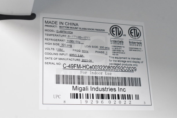 Alt text: Migali C-49FM-HCe commercial freezer label, model and serial number, voltage, refrigerant, ETL certifications, made in China.