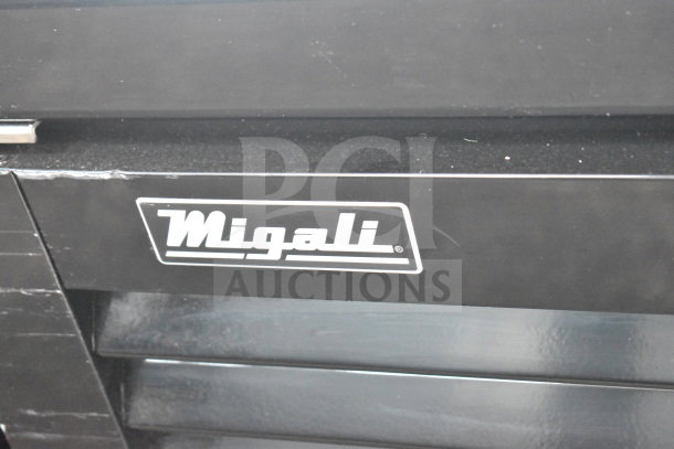 Migali C-49RM-HC logo on a brand new scratch and dent commercial cooler. Visible scratches on the black surface.