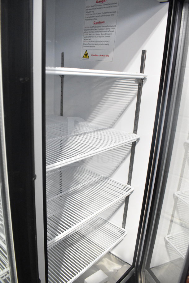 Brand new Migali C-49FM-HC commercial 3-door freezer with shelves, tags visible. Scratch and dent, on casters. 115V, 1 phase.