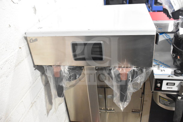 Brand new Curtis G4TP2T10A3500 coffee brewer, twin 1.5-gallon, with touch screen and shelf; minor cosmetic dent.