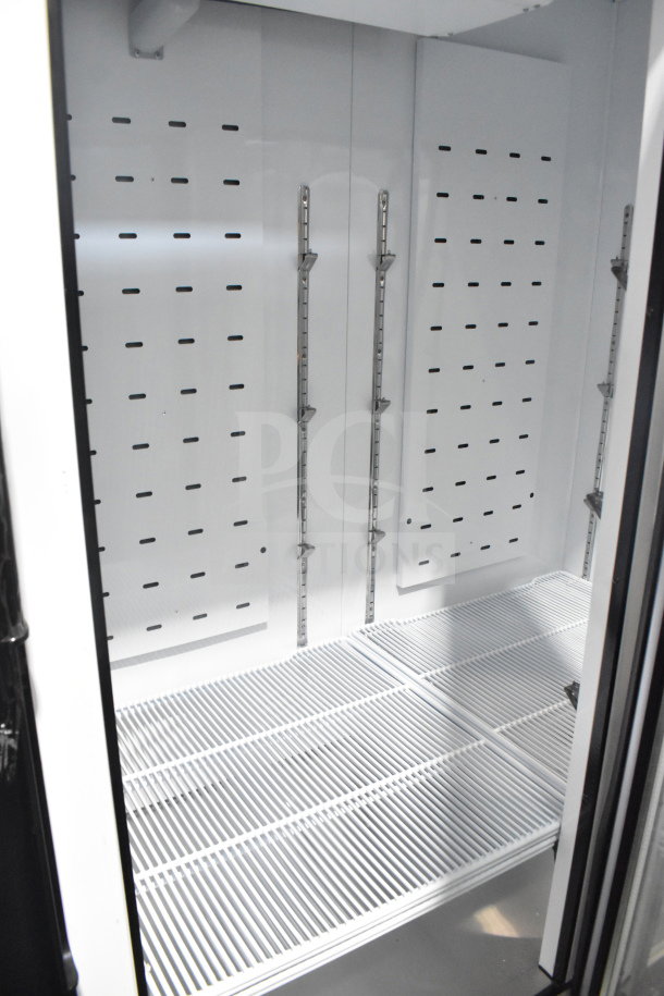 BRAND NEW Migali C-72FM-HC commercial cooler interior, 3 Door, scratch and dent condition, with shelving slots visible.