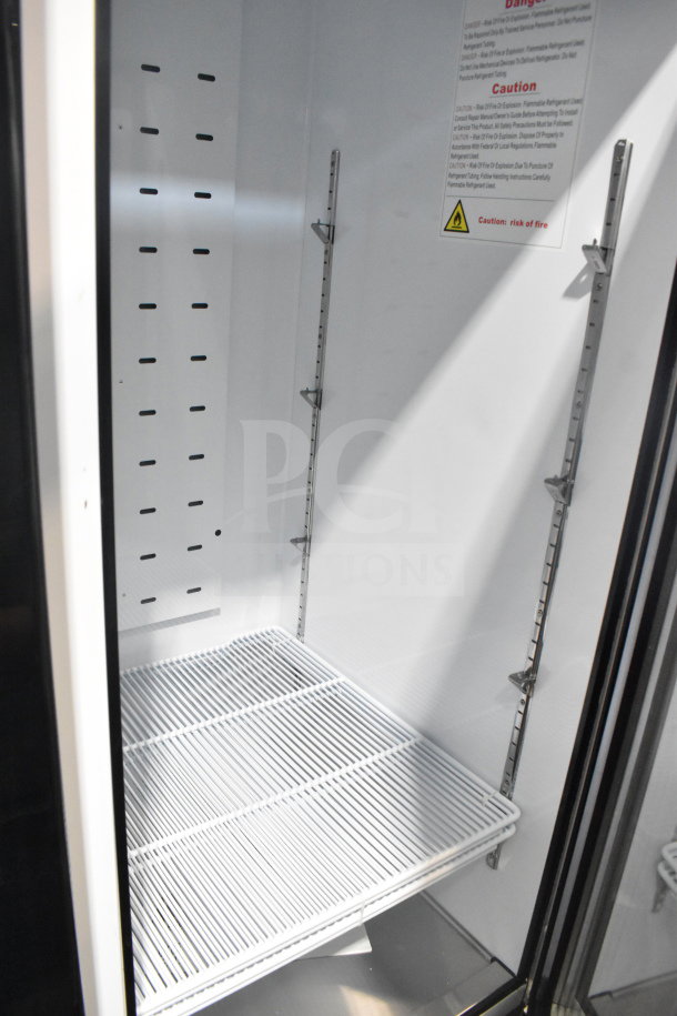 Brand new 2022 Migali C-72FM-HC commercial cooler interior. Features adjustable shelves, warning labels, and pristine condition.