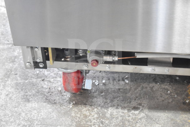 Brand new Migali C-RO8B-NG 8 burner range with 2 ovens, visible commercial caster, and gas connection detail.