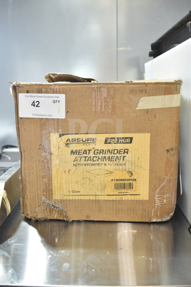 Box of 190M22HGA meat grinder attachment with stomper for #22 hub, new but with scratches and dents, labeled Assure Parts.