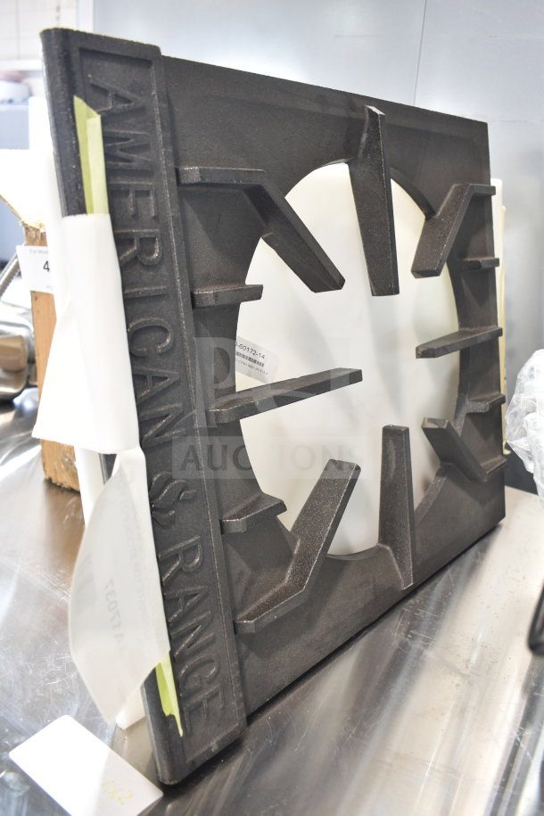 "American Range cast iron burner part, new condition, with visible brand name embossing, positioned on a metallic surface."
