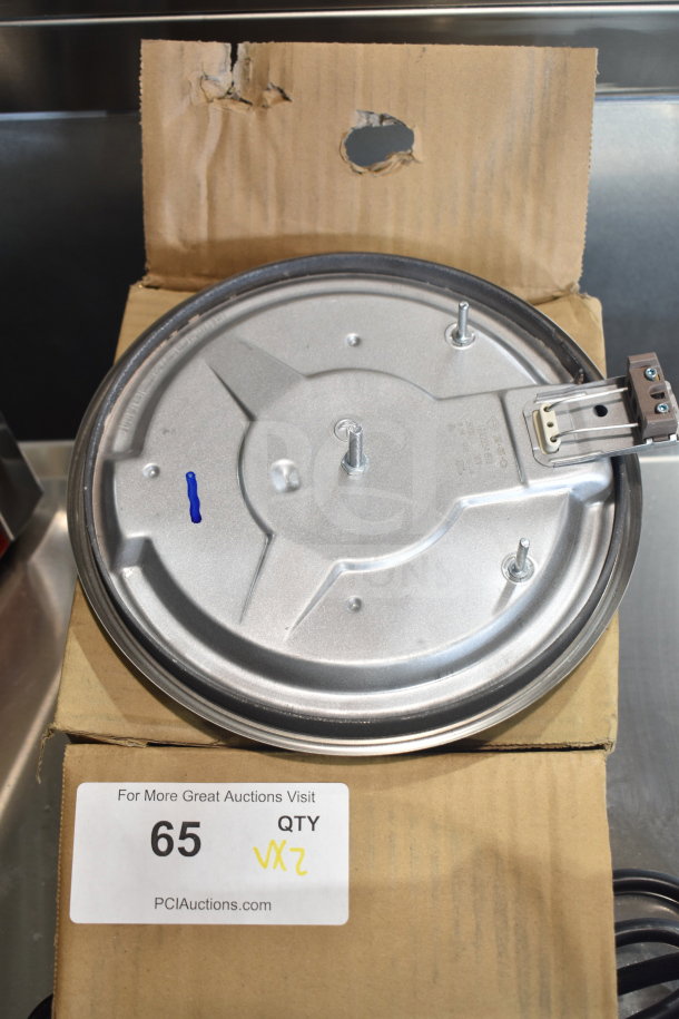 Brand new burner with visible mounting bolts, on a cardboard box marked "65 QTY VX2". Scratch and dent condition.