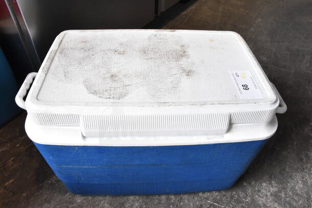 Blue portable cooler with a white lid and side handles. Visible wear on the lid. Auction tag "68 QTY 3."