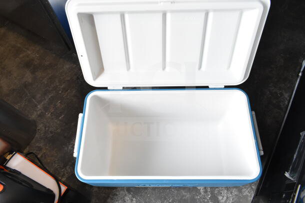 Blue portable cooler with open lid, showing spacious interior. Includes 3 coolers; 2 blue, 1 red. Good condition.