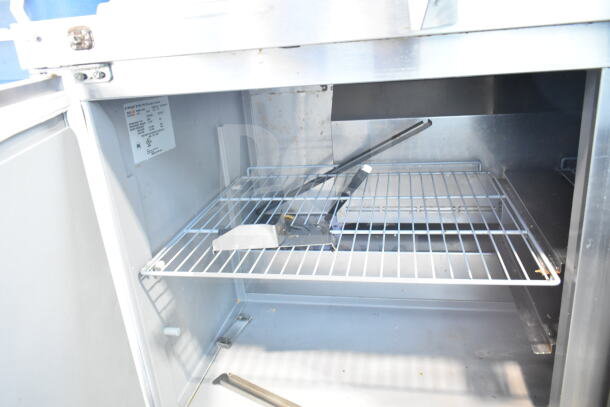 2019 Delfield 4460NP-24M sandwich prep table interior, white wire shelf, good condition, electrical specs label visible.