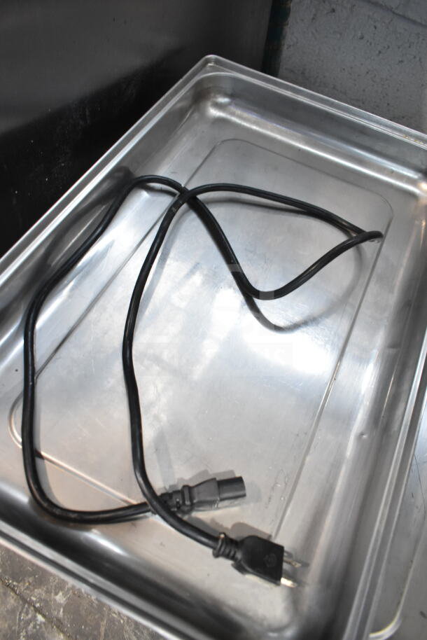 Auction lot with footed plates, chafer lids, and a power cord on a metal tray. All items in used condition.