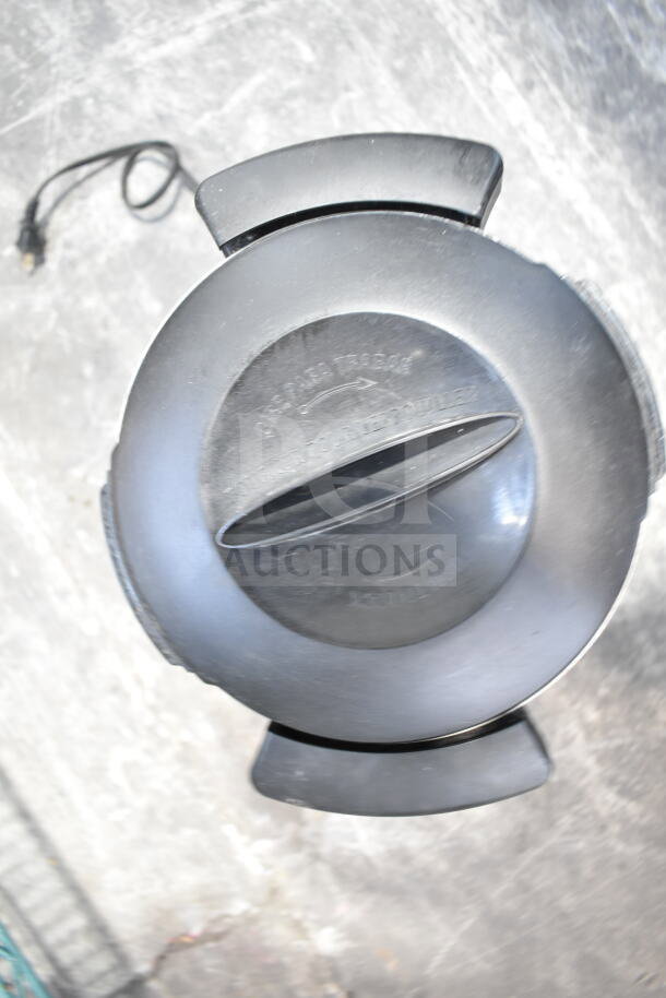 Hamilton Beach beverage holder dispenser, black, top view showing sealed lid with grip handle. Electrical cord visible.