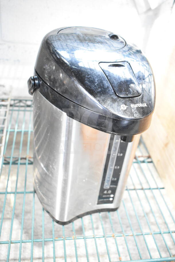 Eurolux beverage dispenser with black lid, visible markings, stainless steel body on wire shelf; includes Hamilton Beach holder.