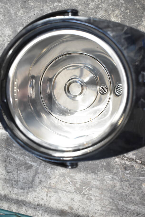 Hamilton Beach Beverage Holder Dispenser interior, shiny stainless steel, two pour spouts; reflects clean, maintained condition.