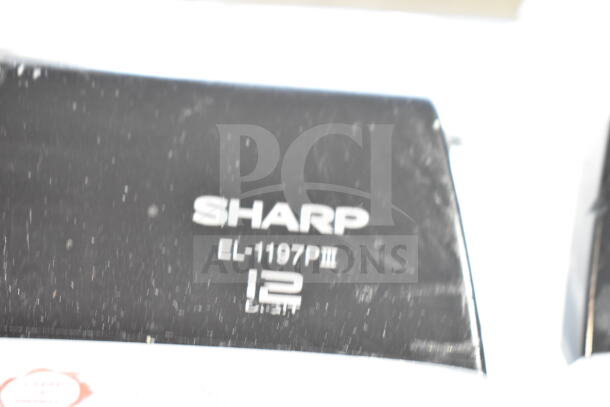 Sharp EL-1197PIII printing calculator, black, close-up of logo and model number. Auction includes two calculators.