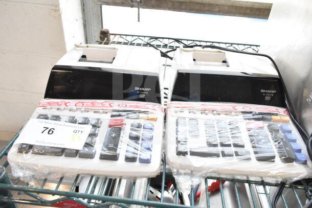 Two Sharp EL-1197PIII printing calculators, lightly packaged, model visible, on metal shelf, auction tag reads 76.