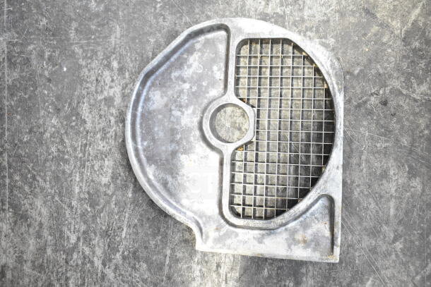 Metal grid blade with a circular hole, used condition, seen on a textured surface. Part of a set.