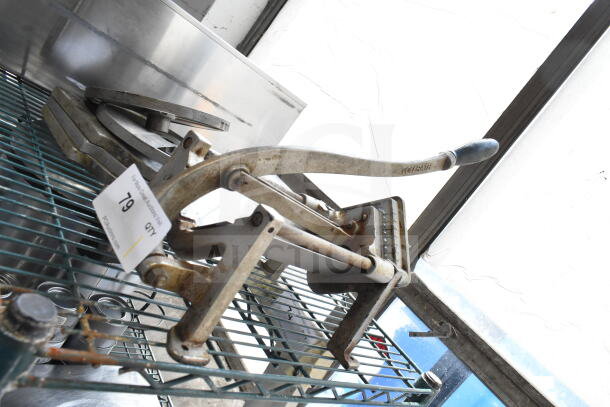 Countertop French fry cutter with metal frame and lever, showing some rust. Auction lot tag marked "79" visible.
