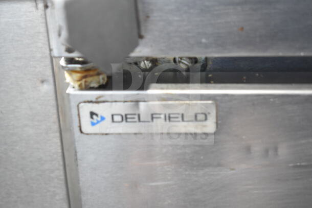 Delfield 4448NP-18M-A5 prep table with visible logo plate, stainless steel finish, commercial grade condition.