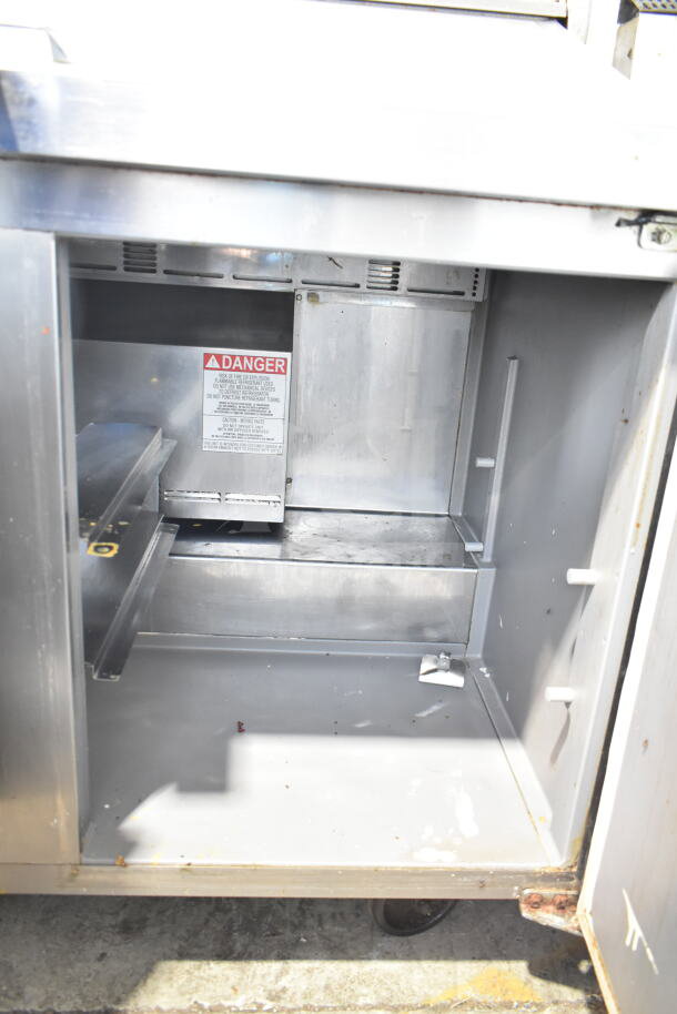 Delfield 4448NP-18M-A5 commercial sandwich prep table, stainless steel, 115V, 1 phase, internal view, visible safety label.