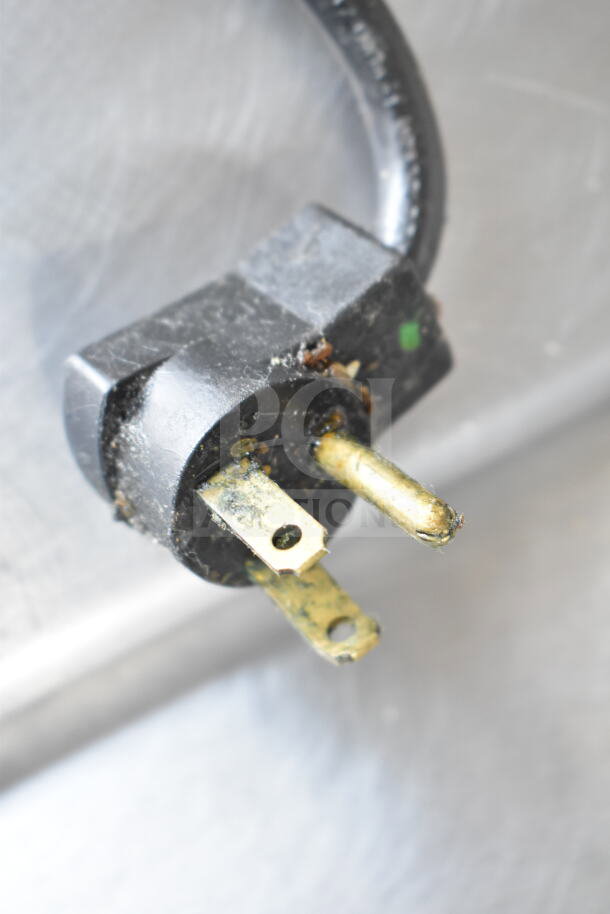 Close-up of a power plug for a Delfield 4448NP-18M-A5 commercial prep table. Condition shows wear and dust.
